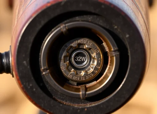 Detailed shot of a 32WIN cartridge in a Winchester rifle chamber, highlighting precision and craftsmanship for firearm enthusiasts.
